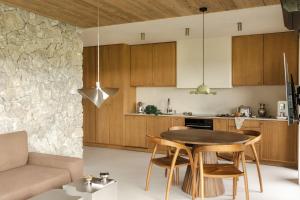 a kitchen and living room with a table and chairs at Baniska Houses Mountain View DOM Z WIDOKIEM NA TATRY JACUZZI ORAZ SAUNA W CENIE in Szaflary