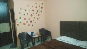 a bedroom with a bed and two chairs and a table at PG - Sudha sadan in Lucknow
