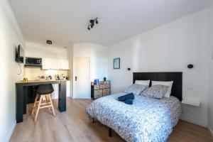 a bedroom with a bed and a desk and a kitchen at Casa 159 - SAINT QUENTIN in Saint-Quentin
