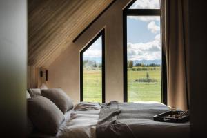 a bedroom with a bed and a large window at Baniska Houses Mountain View DOM Z WIDOKIEM NA TATRY JACUZZI ORAZ SAUNA W CENIE in Szaflary