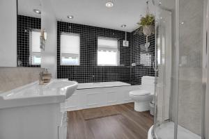a bathroom with a tub and a sink and a toilet at Saltdean Sea Haven in Saltdean +13 photos