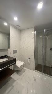 een badkamer met een douche, een toilet en een wastafel bij Long Beach, İskele, Grand Sapphire Resort - Pool View Luxury Studio in Paralimni