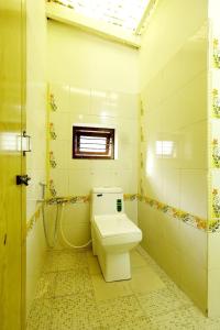 a bathroom with a toilet and a window at Balur Homestay in Chikmagalur