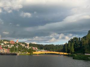 a bridge over a lake with a town in the background at Sungava homestay in Mirik