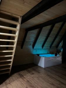 a attic room with a hot tub and a ladder at Vila INNA in Dubrave Gornje
