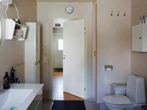 a bathroom with a toilet and a clock on the wall at 4 star holiday home in Sollentuna in Sollentuna +30 photos