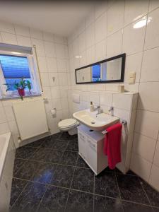 a white bathroom with a sink and a toilet at Ferienwohnung Familie Baus in Hammelburg +27 photos