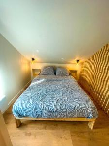 Un dormitorio con una cama con un edredón azul y blanco. en Charmant duplex près du port de Perros-Guirec, en Perros-Guirec