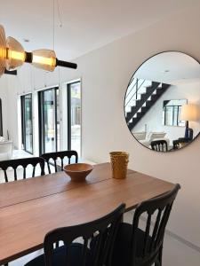 a dining room with a wooden table and a mirror at Sunshine pool villa 2新築ラグジュアリーリゾートヴィラ天然芝ゴルフサウナ完備 in Katakai