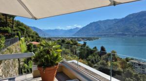 a balcony with a view of a lake and mountains at Sollevante Ascona mit Pool und fantastischer Seesicht in Ascona