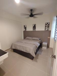 a bedroom with a bed with a ceiling fan at Kuromi Homestay Port Dickson Ground Floor in Port Dickson