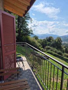 a porch with a bench and a view of the mountains at Casa Nogo in Cadro +7 photos