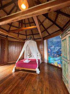 a bedroom with a bed with a mosquito net at Waecicu Eden Beach Hotel in Labuan Bajo