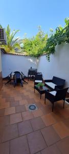 a patio with black benches and a white wall at Alojamiento Casa Tía Mari in El Robledo
