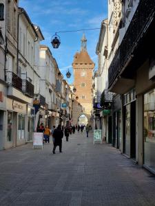 a city street with a clock tower in the distance at Stelina Haussmann - Balcony in Villeneuve-sur-Lot
