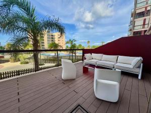 a patio with a couch and chairs on a balcony at Lucerna II, Bajo 2 in Dehesa de Campoamor