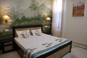 a bedroom with a bed with a painting on the wall at Otla - A Heritage Boutique Hotel, Jaipur in Jaipur +97 photos