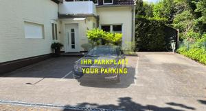 ein in einer Einfahrt geparktes Auto mit einem Schild darauf in der Unterkunft FERINO - zentral & ruhig - Glasfaser WLAN & LAN - privater Parkplatz in Gütersloh
