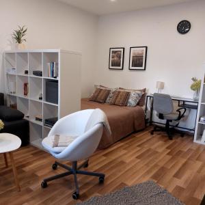 a bedroom with a bed and a desk and a chair at Skandi Garzon in Dunaújváros