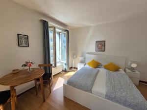 a bedroom with a bed and a wooden table at Julia Zimmer Luzern in Luzern