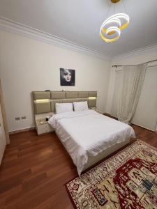 ein Schlafzimmer mit einem großen weißen Bett und einem Teppich in der Unterkunft فيلا مع حمام سباحه وحديقه 0306-888-0106 in Kairo