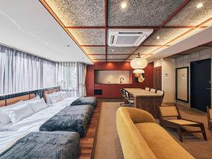 a hotel room with four beds and a table at illi Jam Shinsaibashi in Osaka +54 photos