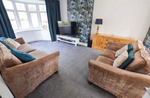 a living room with two couches and a television at Coastal Corporate Stays in Blythe