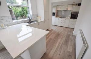 a white kitchen with a large white counter top at Coastal Corporate Stays in Blythe +5 photos