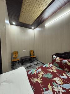 a bedroom with a bed and two chairs in it at Chirag Homestay Kainchi in Nainital +46 photos