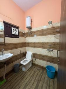 a bathroom with a toilet and a sink at Chirag Homestay Kainchi in Nainital