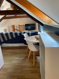 ein Esszimmer mit Tisch und Stühlen und einer Couch in der Unterkunft Grand appartement Fay centre in Fay-aux-Loges