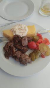a plate of food with meat and vegetables on a table at White River in Rîu Alb de Jos