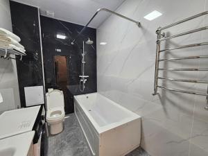 Un baño con bañera y WC. en Bobs apartments, en Samarkand