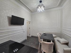 Una sala de estar con un sofá, una mesa y un televisor. en Bobs apartments, en Samarkand