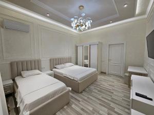 Un dormitorio con dos camas y una lámpara de araña. en Bobs apartments, en Samarkand