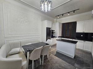 cocina con mesa, sillas y barra en Bobs apartments, en Samarkand