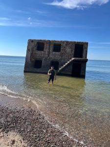 a man standing in the water at the beach at Dzīvoklis īstermiņā in Liepāja +6 photos