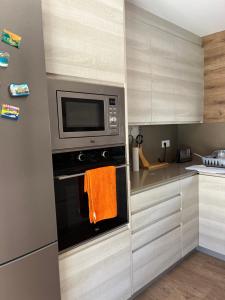 a kitchen with a microwave oven with an orange towel at Villa Buiza in Cunit