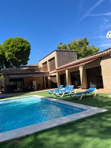 a house with a swimming pool and two lounge chairs at Villa Buiza in Cunit +18 photos