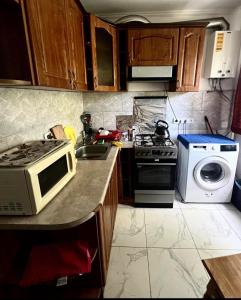 a kitchen with a microwave oven and a stove at Гарне помешкання in Uzhhorod