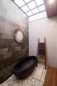 a bathroom with a black bath tub and a mirror at Villa CanSavina - 3 Rooms - Center Of Seminyak in Seminyak