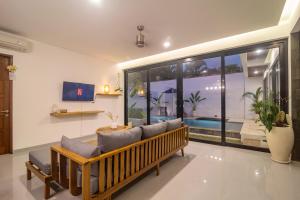a living room with a couch and a large window at Villa CanSavina - 3 Rooms - Center Of Seminyak in Seminyak