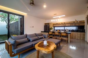 a living room with a couch and a table at Villa CanSavina - 3 Rooms - Center Of Seminyak in Seminyak