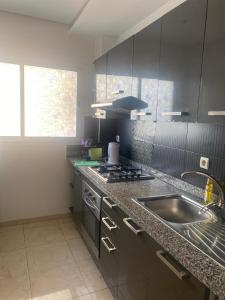 a kitchen with a sink and a stove at Apartment Casa Marina - Borgone, Ocean & Hassan II Views in Casablanca +14 photos
