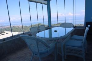 a table and chairs in a room with windows at Kartal Gözü Dağ Evi in Ardeşen