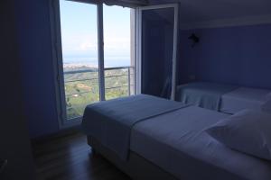 a bedroom with two beds and a large window at Kartal Gözü Dağ Evi in Ardeşen