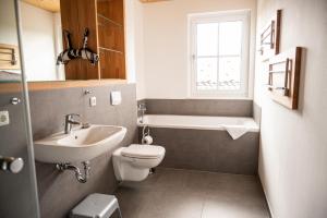 a bathroom with a sink and a toilet and a window at Fh "luv" in Ueckermünde +20 photos