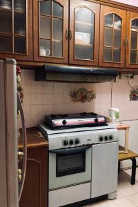 eine Küche mit einem weißen Herd und Holzschränken in der Unterkunft Mia Homestay in Kuala Terengganu