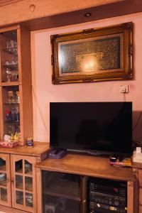 einen Flachbild-TV auf einem Entertainment-Center in der Unterkunft Mia Homestay in Kuala Terengganu
