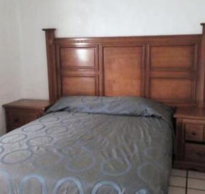a bed in a bedroom with a wooden head board at Condominio BrisaSol in Manzanillo